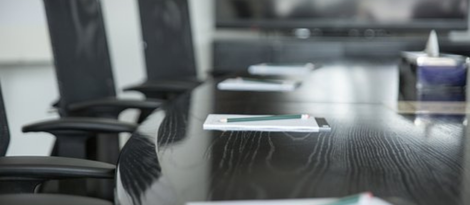 Board room table with empty chairs around it